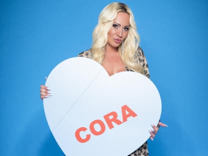 Cora Schumacher hält ein großes Herz vor sich