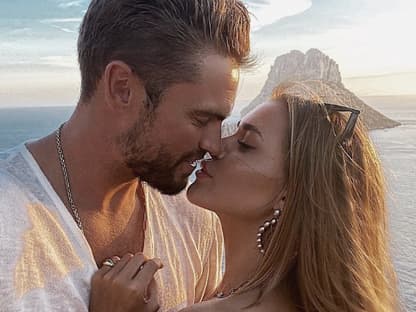 Johannes und Jessica Haller küssen sich fast vor dem Meer.