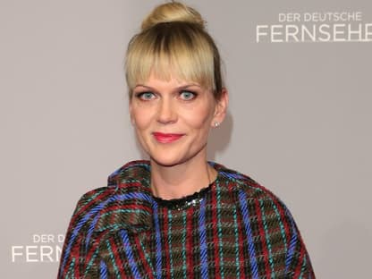 Anna Loos lächelt mit Dutt