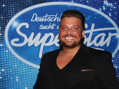 Menowin Fröhlich vor dem DSDS-Logo