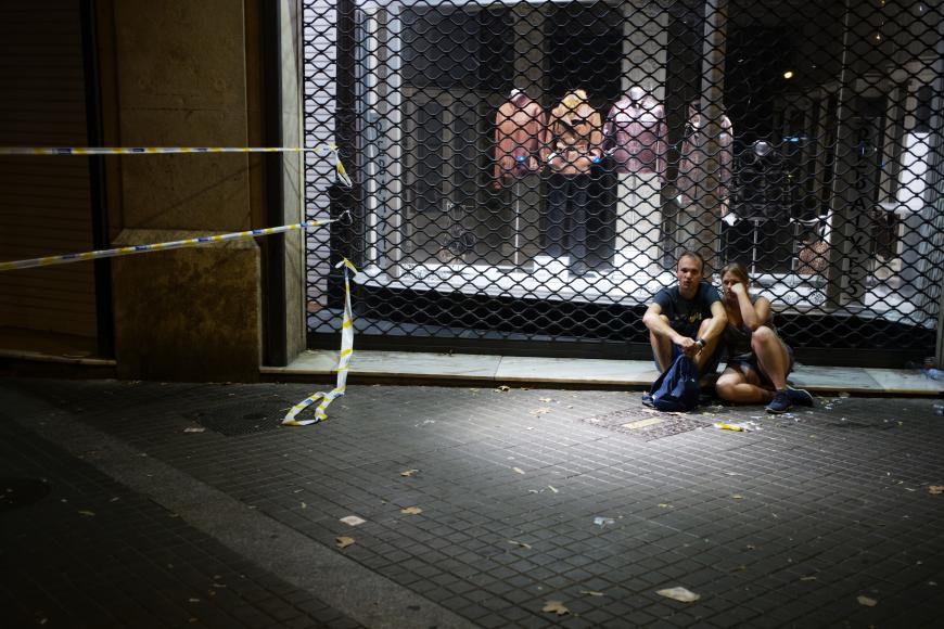 Ein Paar sitzt nach dem schrecklichen Attentat am Straßenrand.