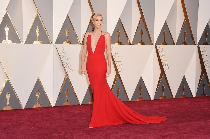 Charlize Theron zeigte viel Haut in einer knallroten Robe von Dior Haute Couture mit XXL-Ausschnitt.