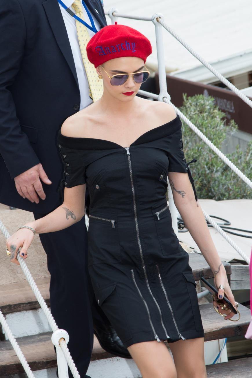 ... ebenso wie Kollegin Cara Delevingne mit roter Kopfbedeckung, passendem Lippenstift und coolem Off-Shoulder-Kleid.