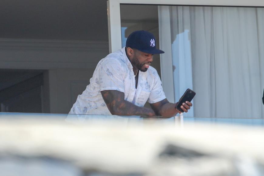 Rapper 50 Cent checkt sein Handy.
