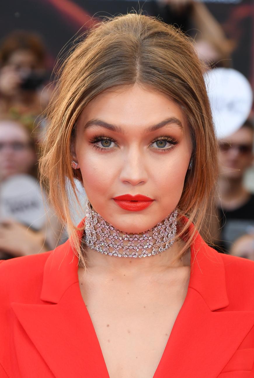 Gigi bei Nacht: Auf dem Red Carpet greift die Schüchternere der beiden zu einem knallroten Lippenstift und leicht goldenem Lidschatten. Wow-Brows rahmen ihr Gesicht perfekt ein.