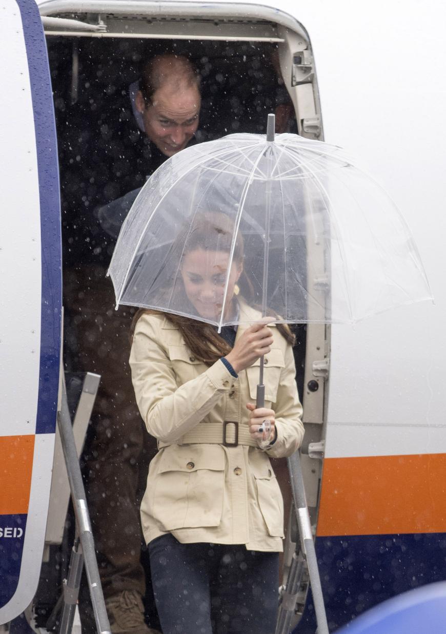 Kate versteckt sich unter einem Regenschirm, als sie am