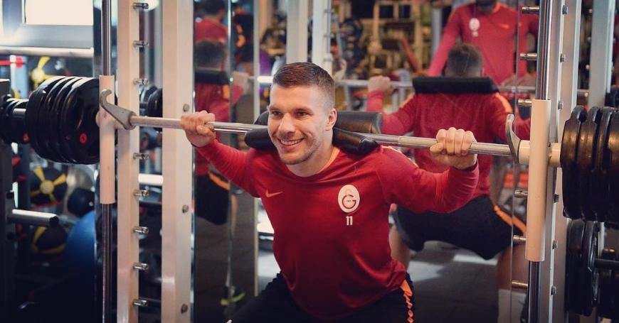 Auch Lukas Podolski hält sich beim Gewichteheben fit - und hat offensichtlich Spaß dabei.