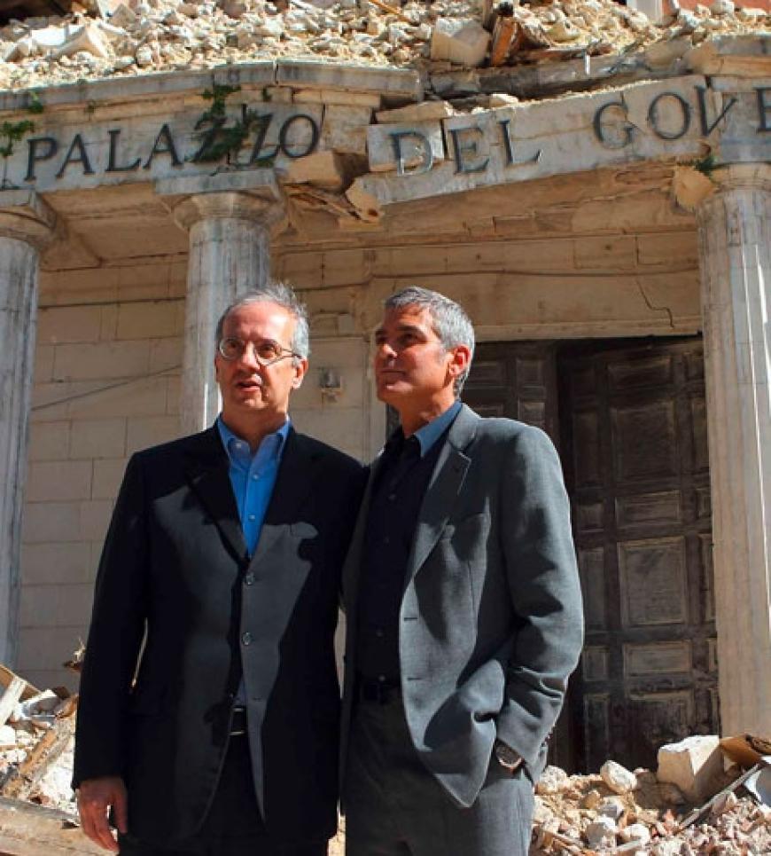 Schriftsteller Walter Veltroni und George Clooney stehen vor einem zerstörten Gebäude. Hunderte Menschen in L´´Aquila sind noch obdachlos