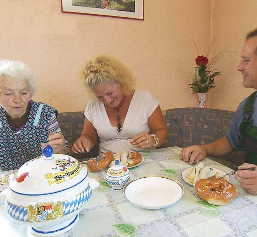 Mit selbstgehackten Holz bereiten Moni und Kunigunde (75) Ackerbauer Markus mit dem Holzofen ein zünftiges Weißwurstessen zu