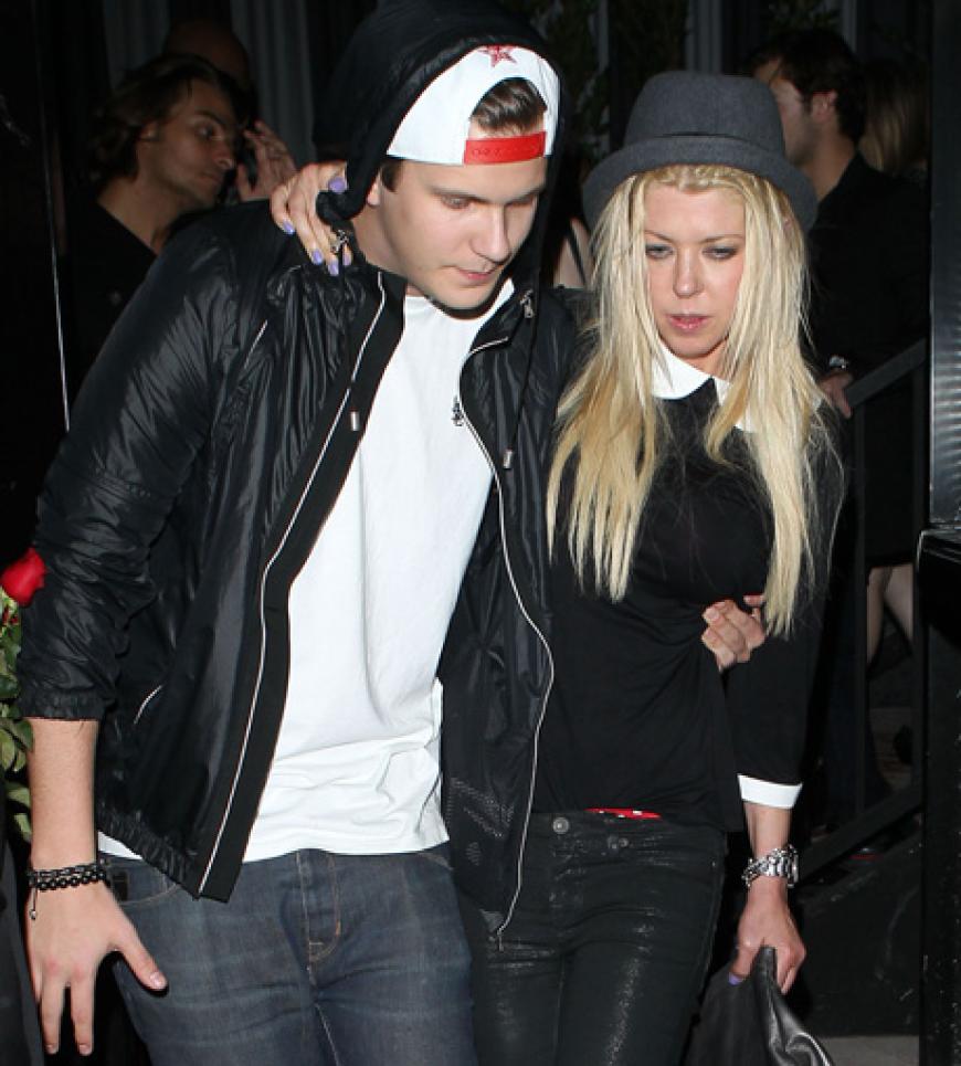 Schauspielerin Tara Reid muss torkelnd von einem Freund gestützt werden.