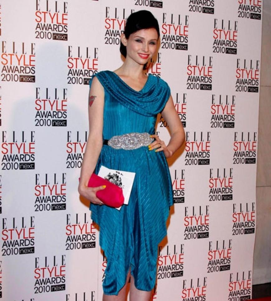 Gewöhnungsbedürftig: Sängerin Sophie Ellis Baxter kombinierte eine pinkfarbene Clutch zu ihrem blauen Kleid. Die lackierten Nägel in Gelb runden den kunterbunten Mix ab