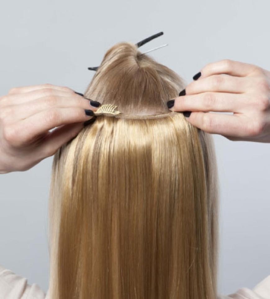 Zuerst am Hinterkopf die schmalere Tresse befestigen. Darauf achten, dass sie mit dem eigenen Haar auf gleicher Länge abschließt! Dann an den Seiten je eine Tresse anbringen