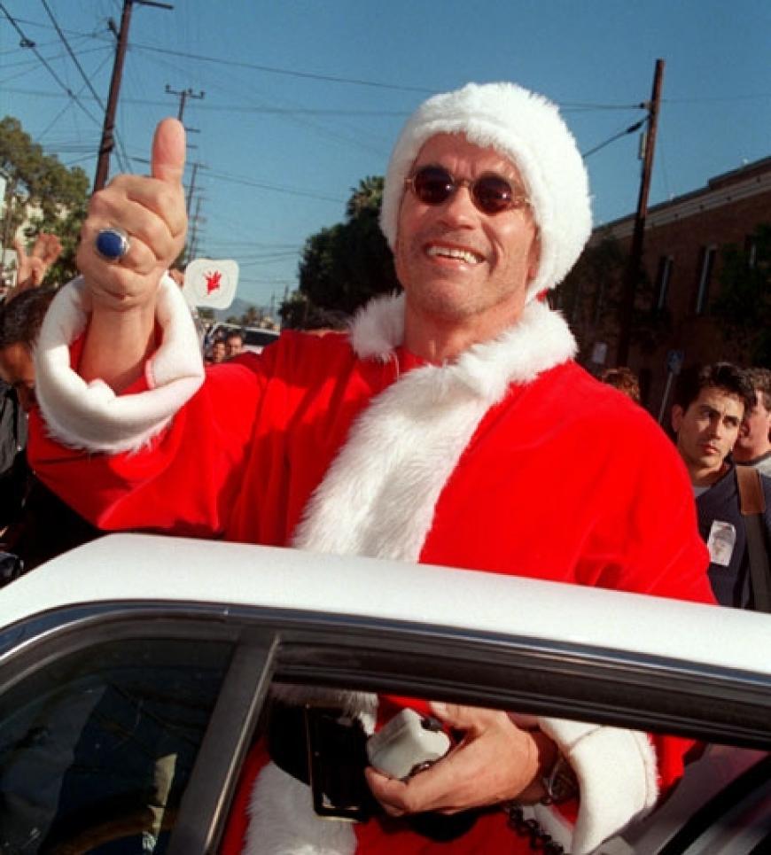 Schauspieler und Gouverneur Arnold Schwarzenegger posiert lässig im Santa Claus-Outfit