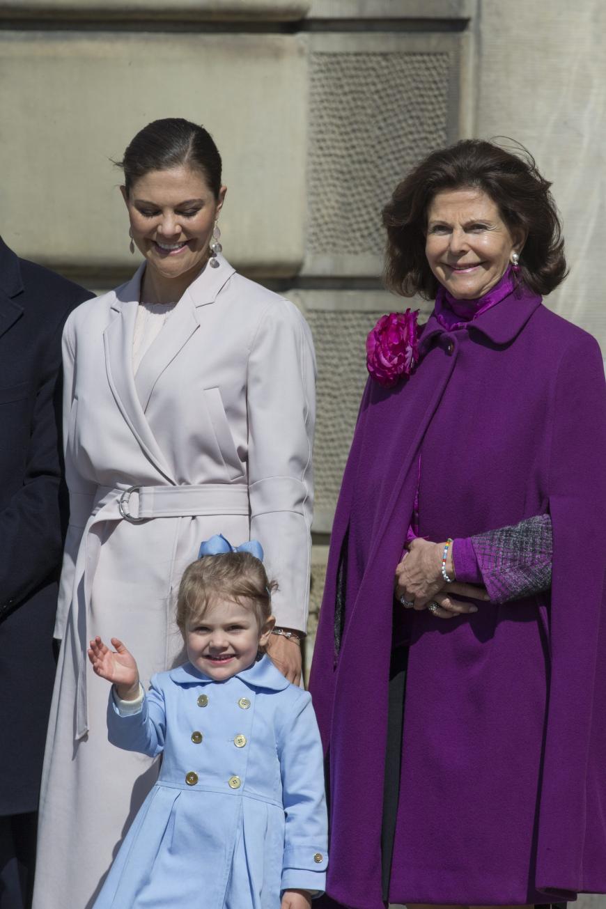 Lieb und brav kann sie aber auch - zumindest kurz: Estelle von Schweden (mit Mama Victoria und Oma Silvia) winkt den Fotografen.