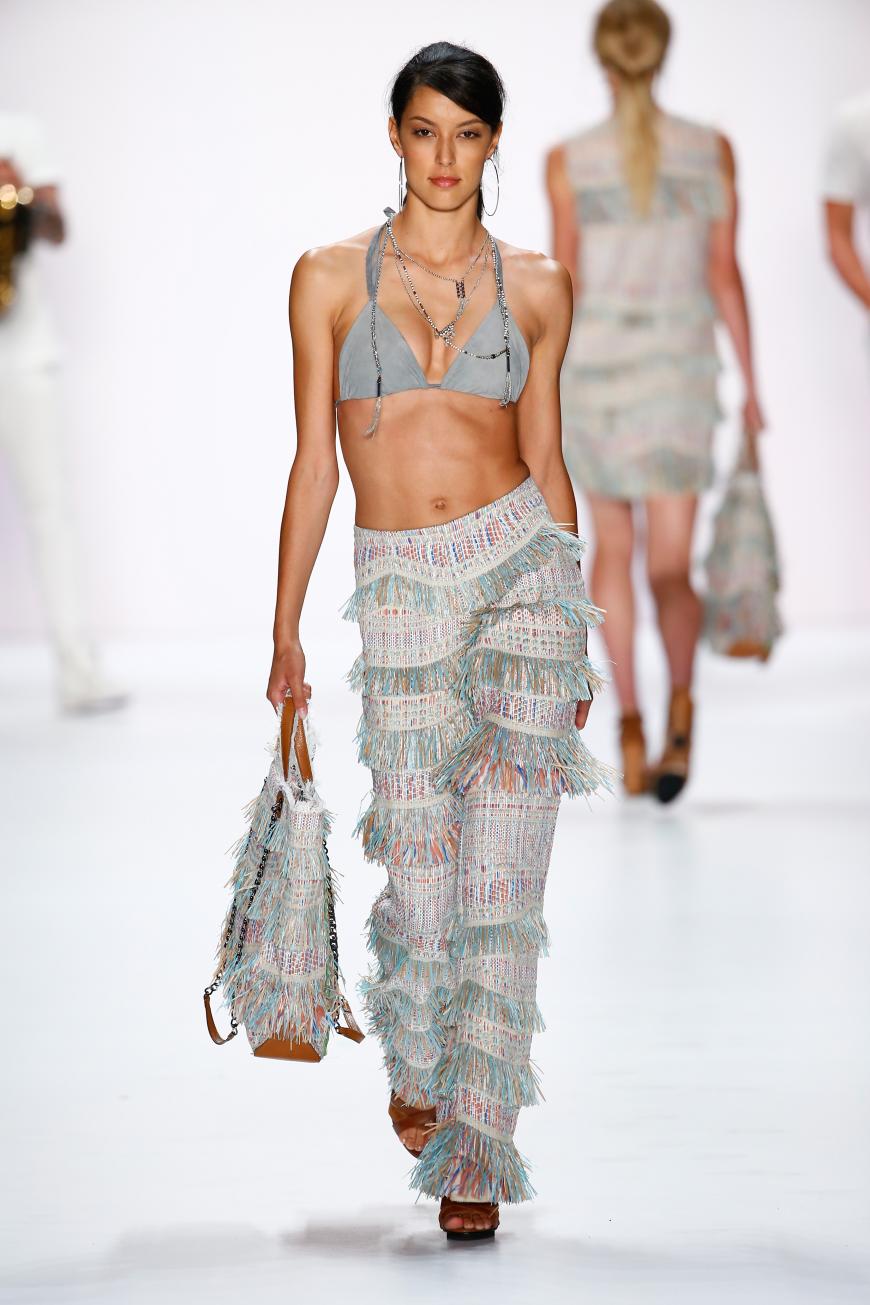 Rebecca Mir zeigte bei der Fashion Show von Riani ihren Wow-Körper in einem Bikini-Oberteil und einer Basthose.