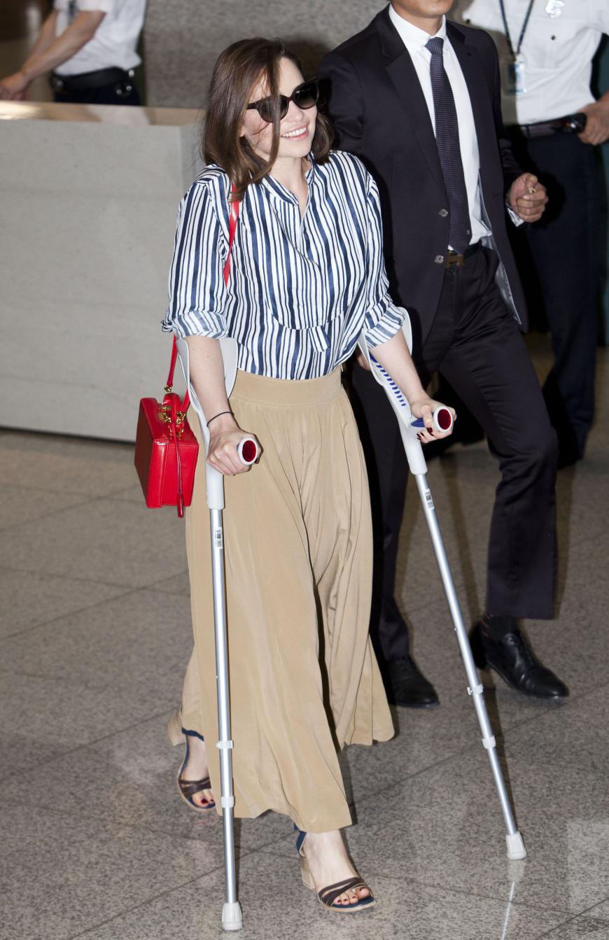Trotz Fußverletzung und Krücken zeigt sich Emilia Clarke am Flughafen in Südkorea in einem ziemlich schicken Look. Zur Streifenbluse kombiniert die Schauspielerin eine trendige Wildleder-Culottes und beweist damit Stilgefühl.