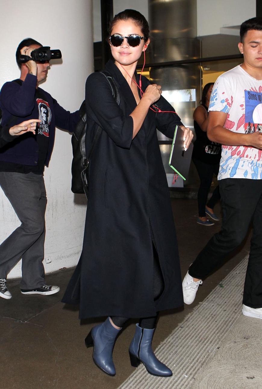 Viel kann man von Selenas Look nicht erkennen, aber ganz schön ladylike sieht die süße Sängerin am Flughafen von L.A. aus! Im schwarzen Oversize-Mantel und coolen Roundglas-Shades macht die 23-Jährige eine ziemlich erwachsene Figur!
