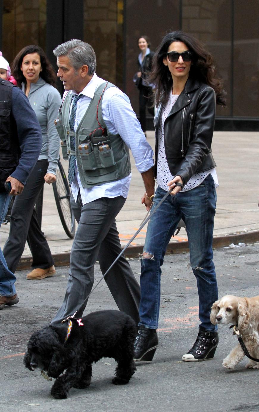 Traumpaar: Amal besucht George in NYC am Filmset und trägt eine Balenciaga-Lederjacke zu Ripped Jeans und weißem Top mit Lochmuster. Dazu kombiniert sie Wedges von Ash und eine Fransentasche von Ferragamo.
