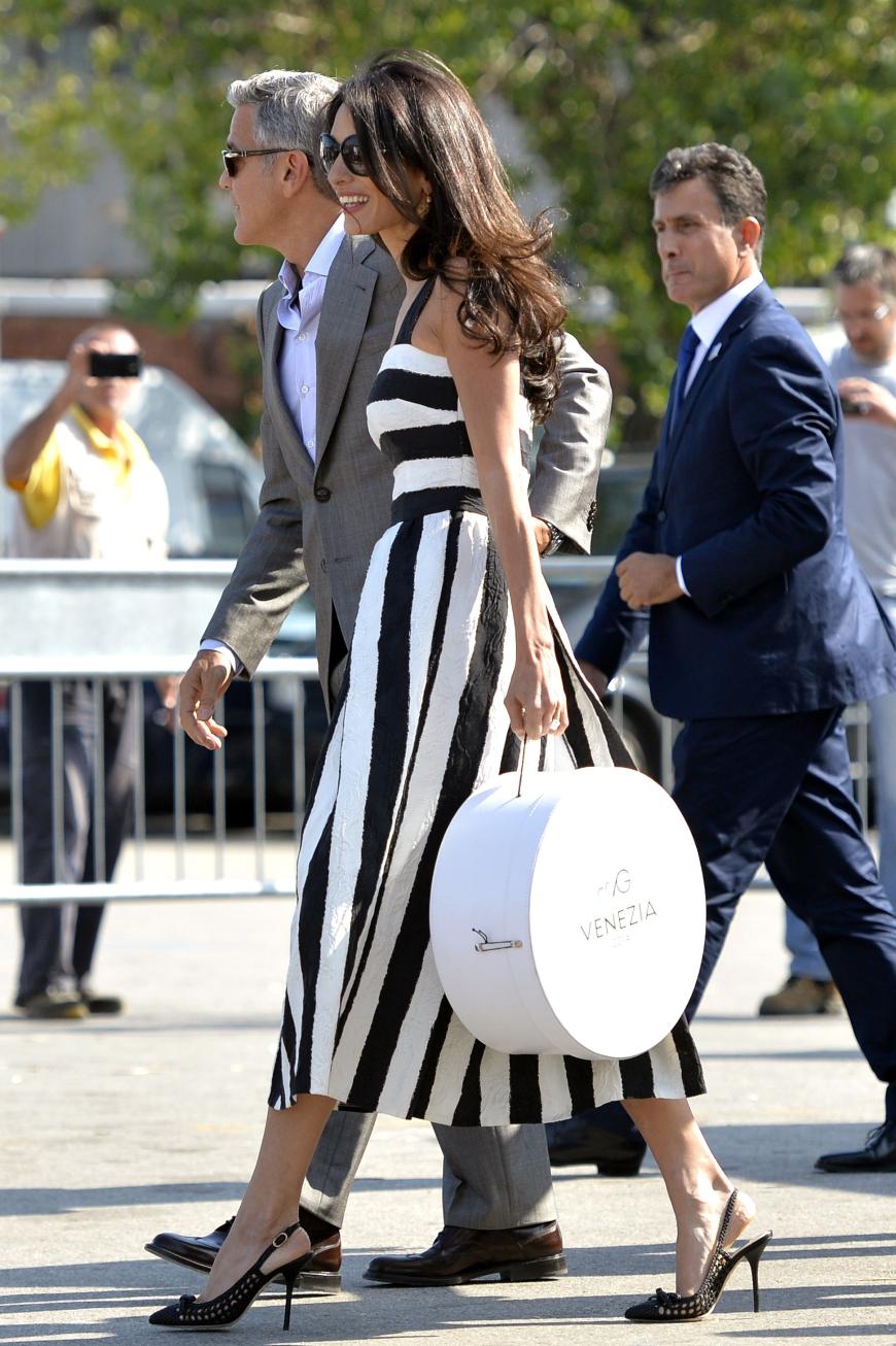 Streifzug durch Venedig: Bei ihrer Ankunft für die große Hochzeit in Italien trägt Amal ein schwarz-weiß gestreiftes Kleid von Dolce & Gabbana mit Slingback-Pumps.