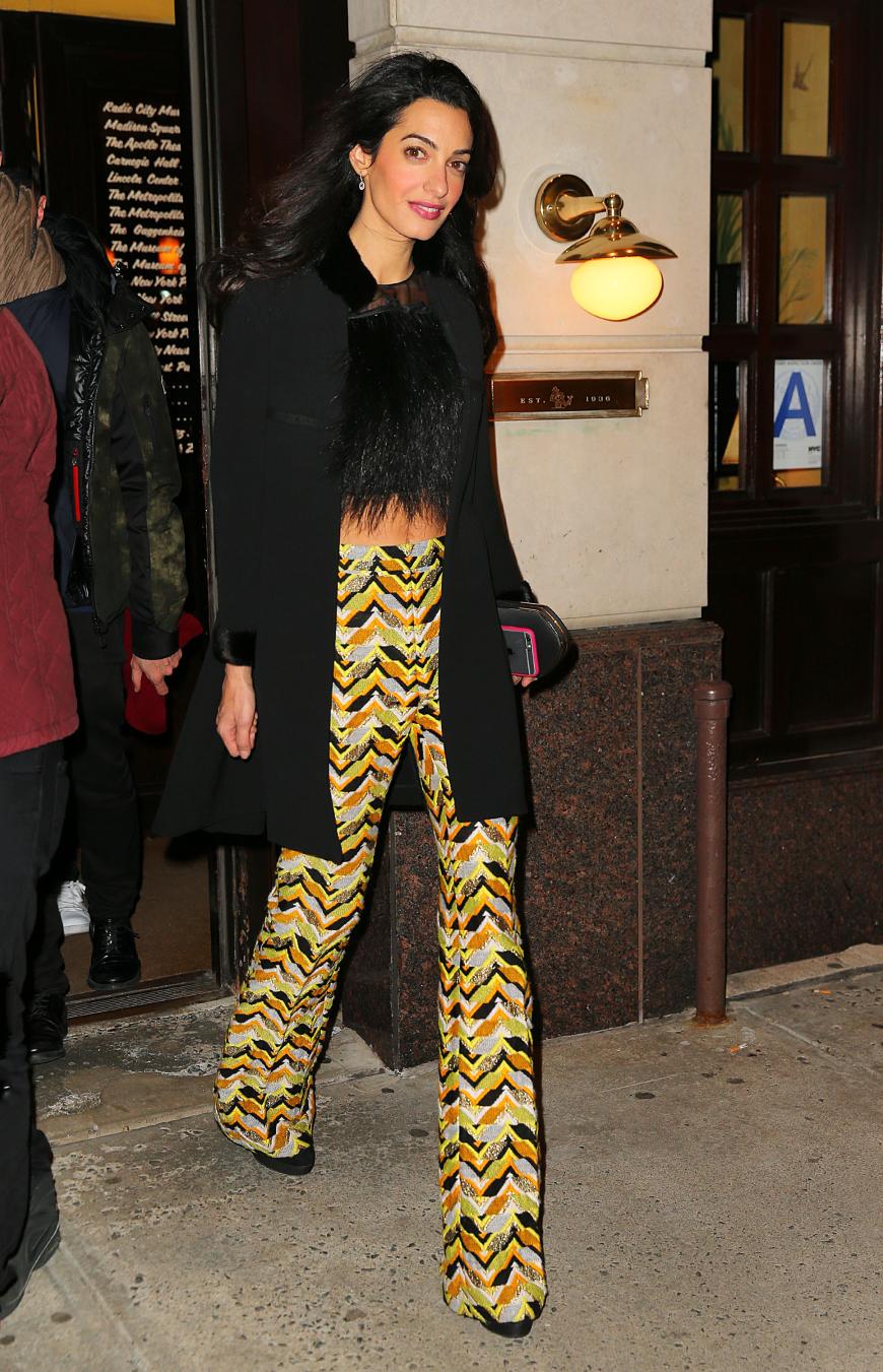 Die Flares von Giambattista Valli beim Abend im Big Apple sind ein echter Hingucker. Dazu kombiniert Amal ein schwarzes Feder-Croptop, Plateau-Boots und einen schwarzen Mantel.