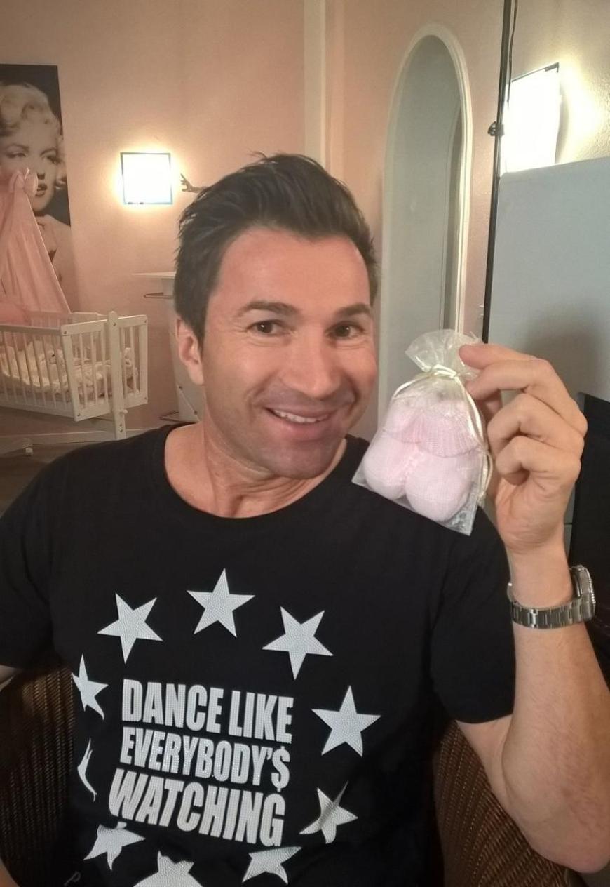 Lucas Cordalis präsentiert happy die Mini-Schühchen für Baby Sophia.