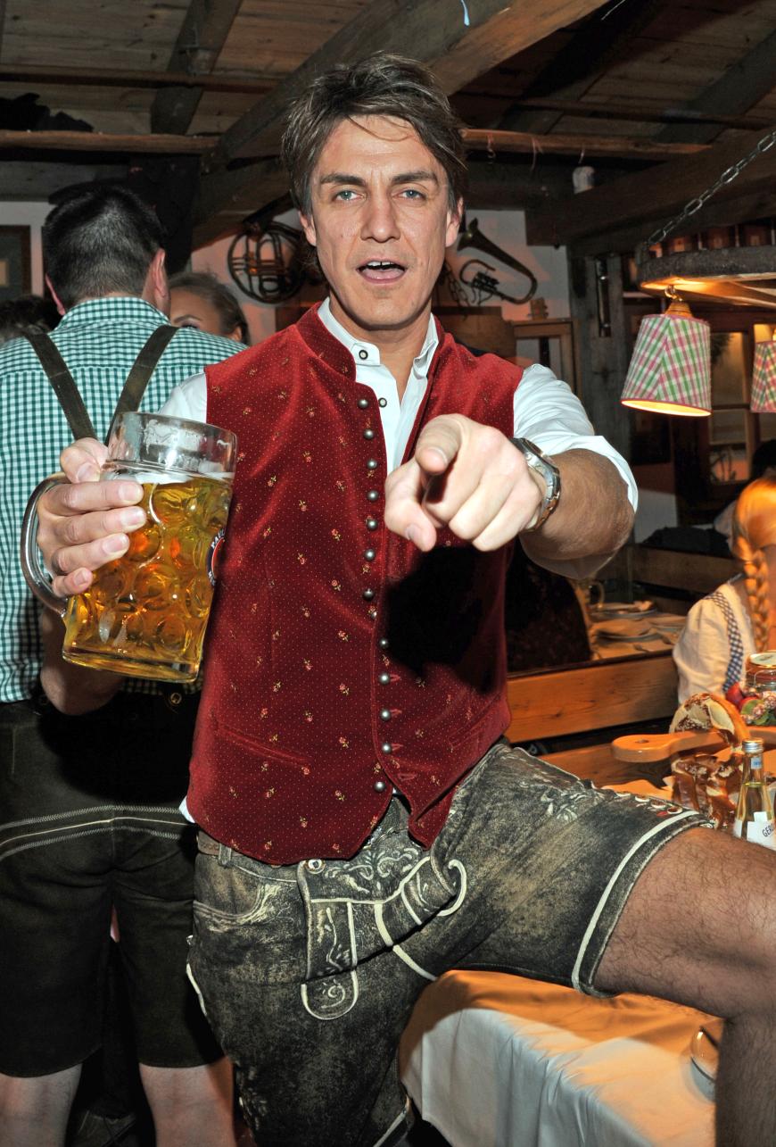 Moderator Matze Knop feiert ausgelassen mit einer Maß in der Hand.