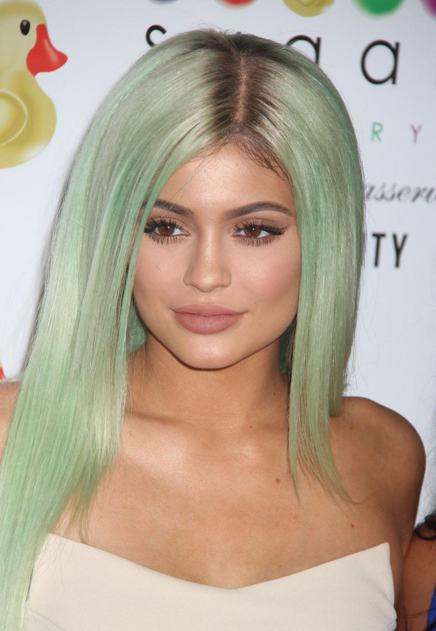 Mit gefärbter Mähne/ Perücke und reichlich Make-up im Gesicht kennen wir Kylie.