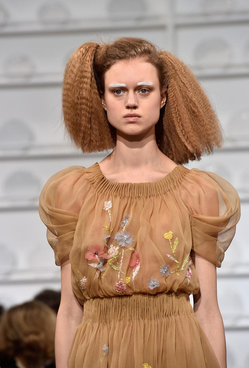 Auch weiße Augenbrauen sind auf dem Catwalk bei Schiaparelli zu sehen. Das Make-up ist hingegen ganz natürlich gehalten.