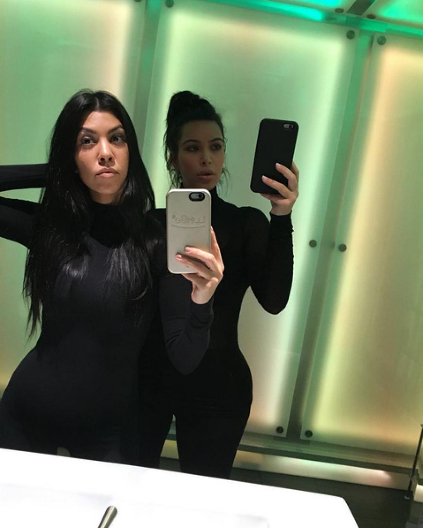 Kourtney Kardashian und Kim Kardashian posieren für ein Selfie.