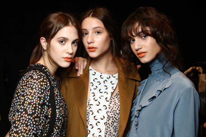 Dorothee Schumacher Models tragen orangefarbene Lippen.