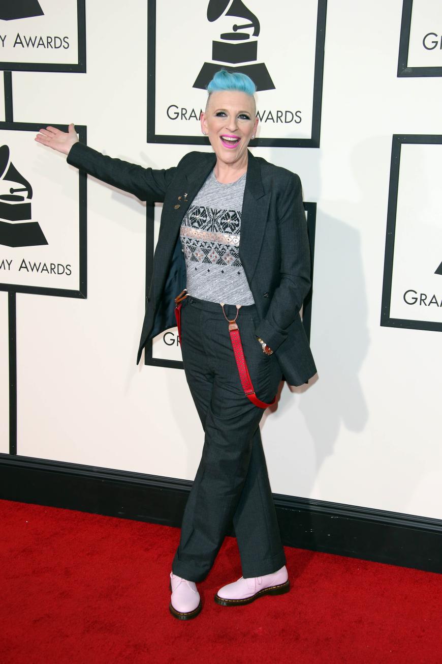 Gute Laune, fieses Outfit: Lisa Lampenelli kombinierte Herrenhosen mit roten Hosenträgern, pinkem Lippenstift und Eisbonbon-farbenen Haaren.