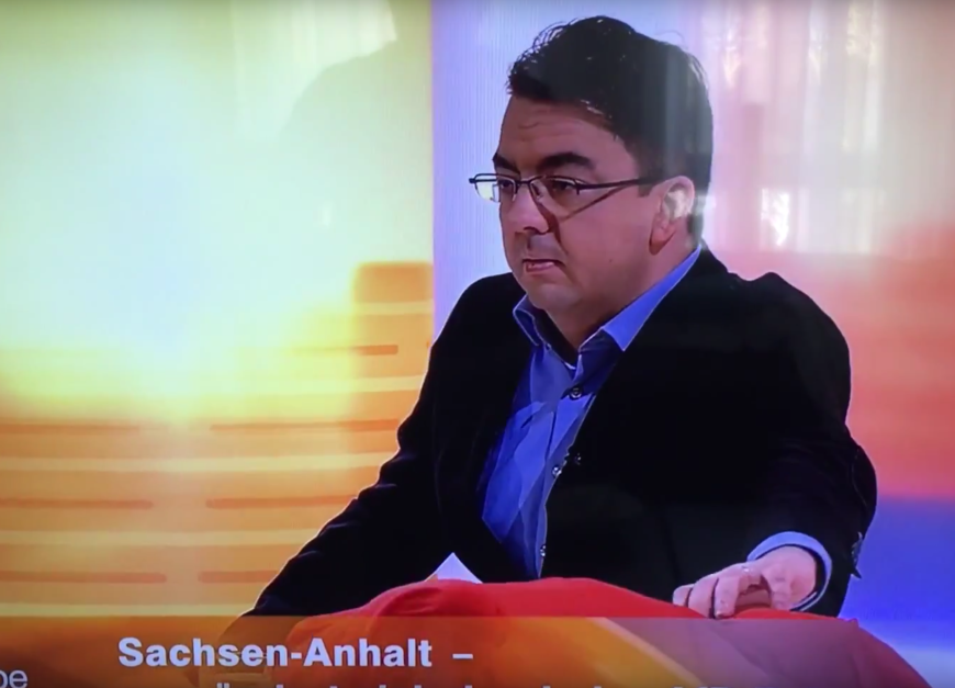 Schock im ZDF-Studio: Moderatorin Babette von Kienlin ist komplett auf dem Moderationstisch zusammengesackt - Experte Thorsten Faas legt ihr hilflos die Hand auf den Rücken.
