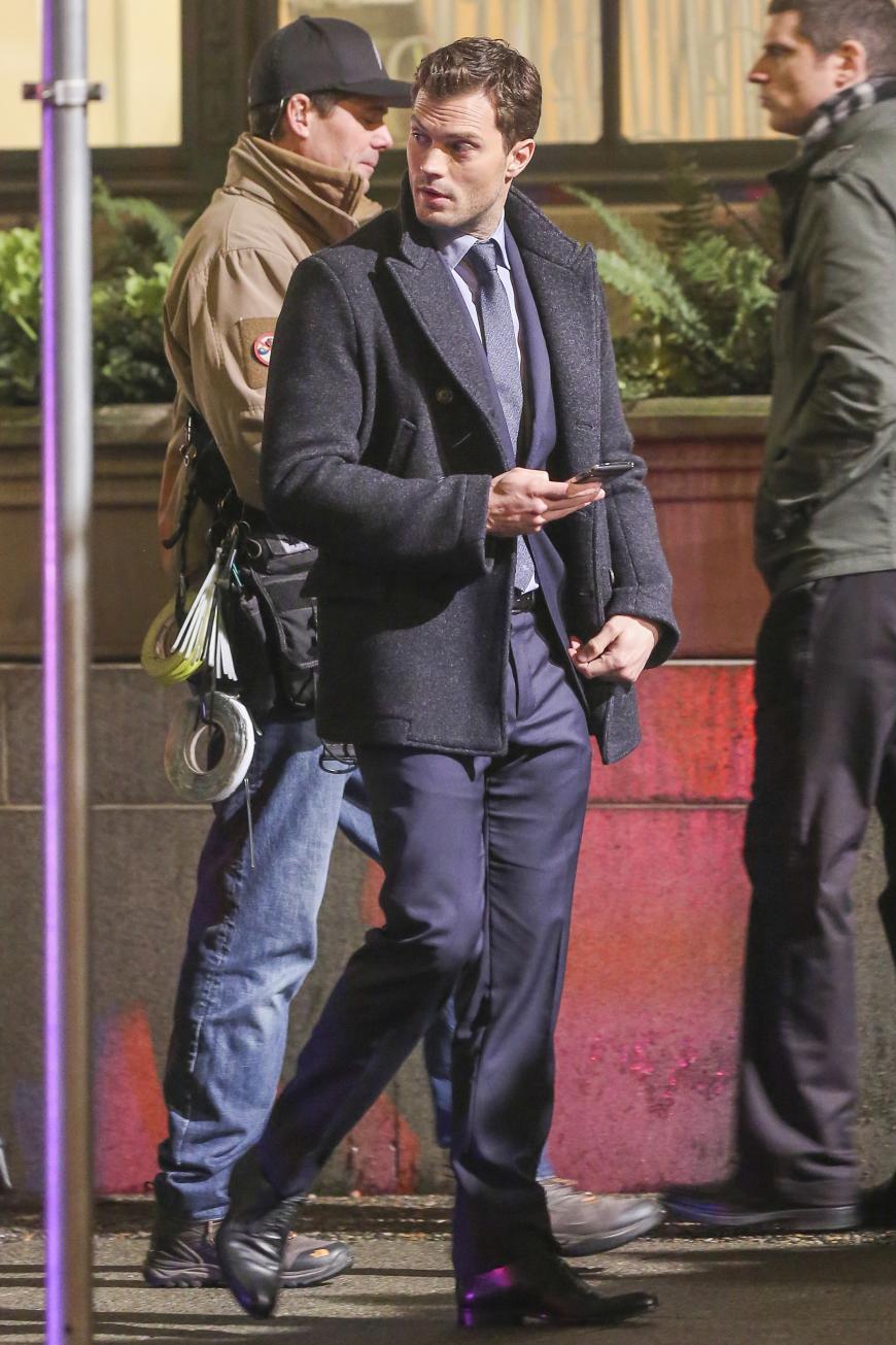 Während der Drehpausen schaut Jamie Dornan auf sein Handy.