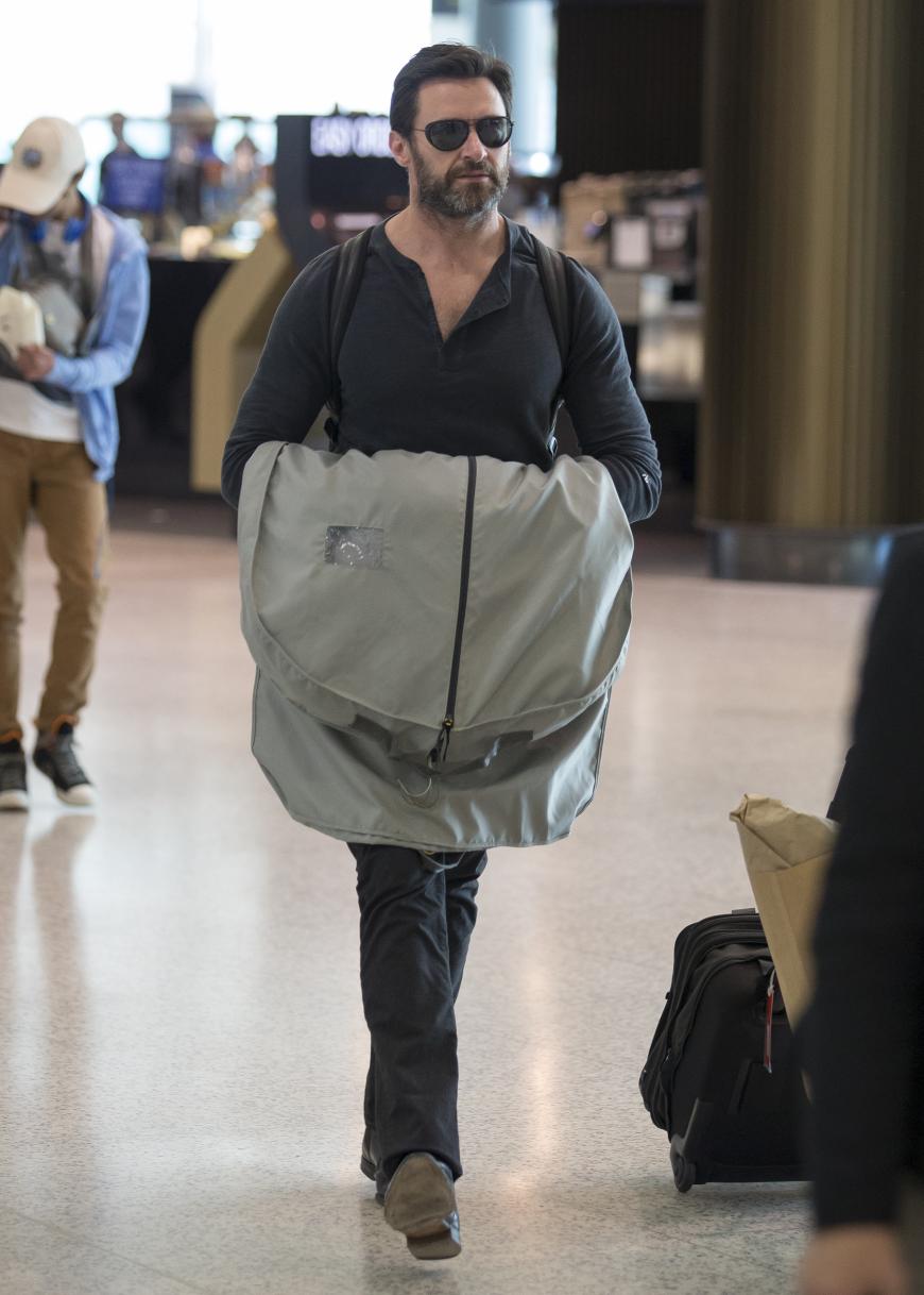 Hugh Jackman läuft mit Kleidersack am Flughafen von Sydney entlang. Mit dabei ist seine ganze Familie mit der er in seiner Heimat urlaubte.