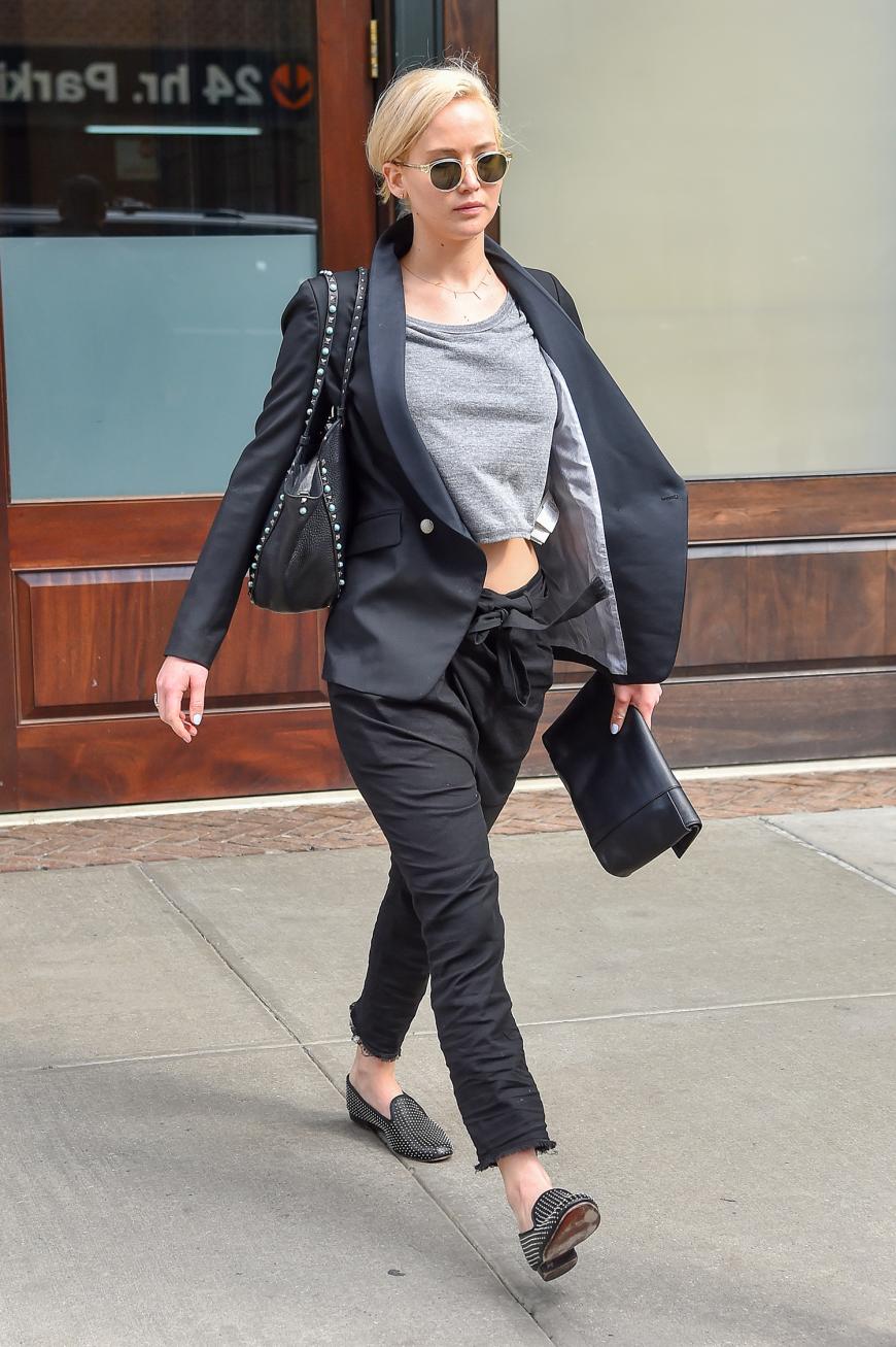 Beim Rennen von Termin zu Termin muss es bequem und trotzdem noch ein bisschen schick sein, weiß Jennifer Lawrence und kombiniert Slipper zur Stoffhose mit grauem T-Shirt und Oversize-Blazer.