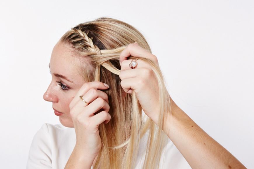 Step 2: Drei Strähnen der vorderen Haarpartie abteilen und seitlich am Haaransatz entlang flechten. Zu jeder Strähne etwas mehr Haar aufnehmen.