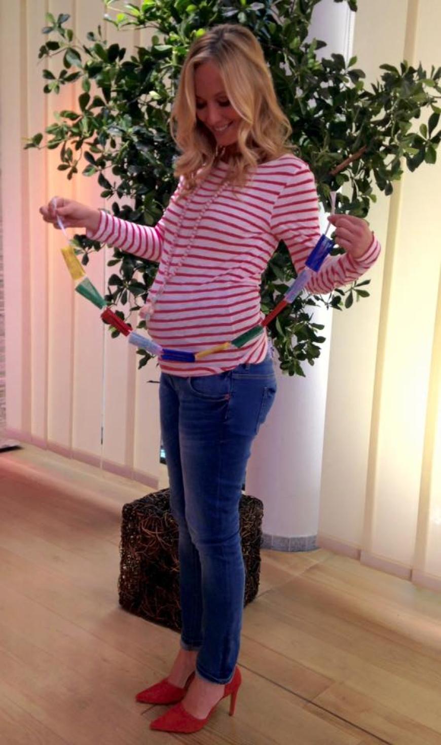 Angela Finger-Erben präsentiert ihren Babybauch.