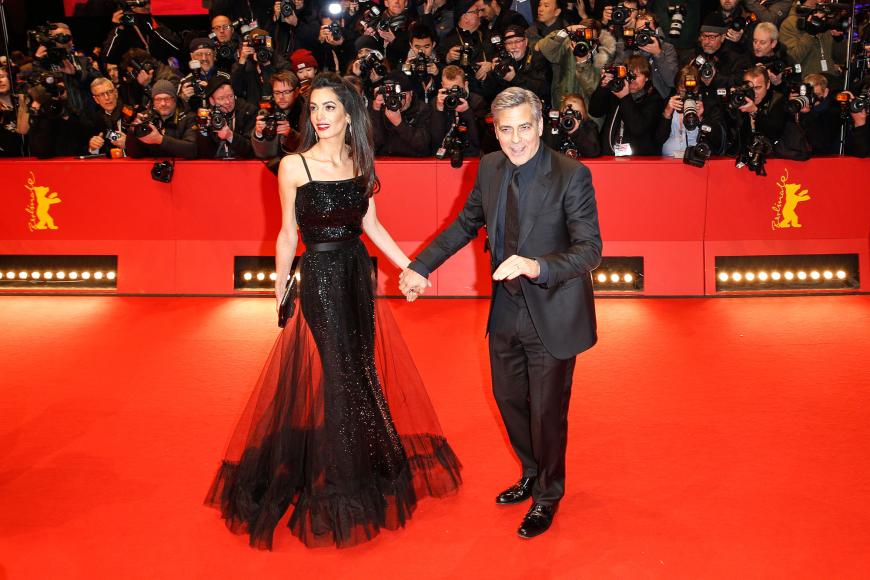 Zur Premiere von „Hail, Caesar!“ ihres Liebsten bei der Berlinale begeisterte Amal in einem Pailletten besetzten, schwarzen Vintage-Kleid von Yves Saint Laurent von 1981 mit transparenter Tüll-Lage darüber.