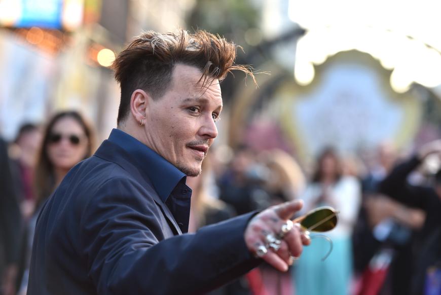 Johnny Depp posiert mit einem Schmunzeln für die Fotografen ...