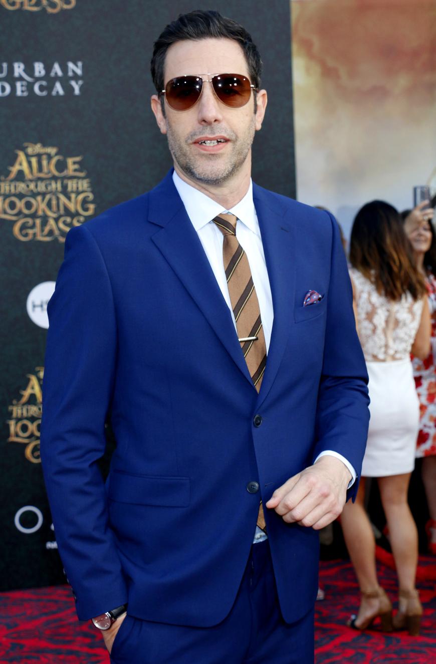 Schauspieler Sacha Baron Cohen würde mit Anzug und Schlips auch als Versicherungsvertreter durchgehen, spielt aber in dem zweiten Teil von „Alice im Wunderland