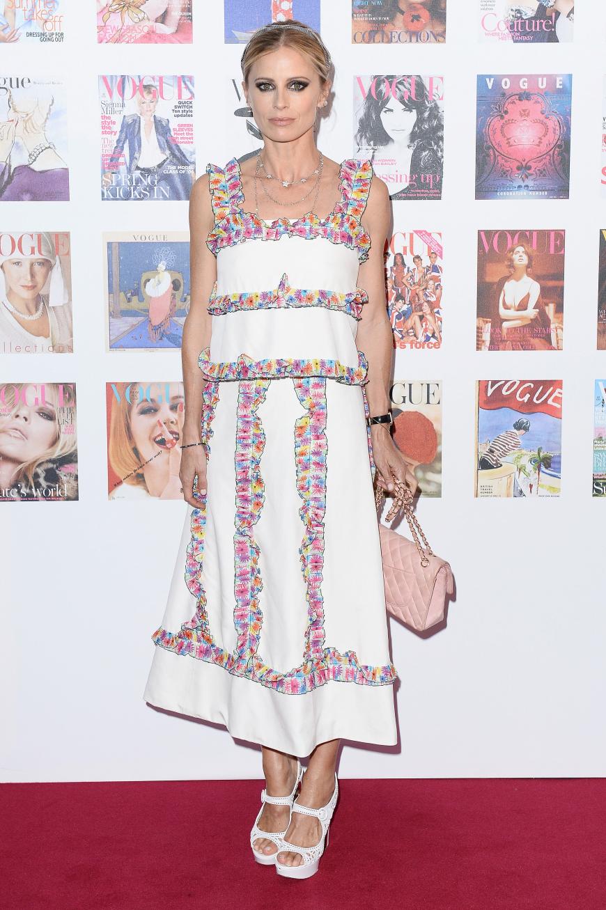 Laura Bailey in einem ungewöhnlichen weißen Kleid mit geblümten Rüschen