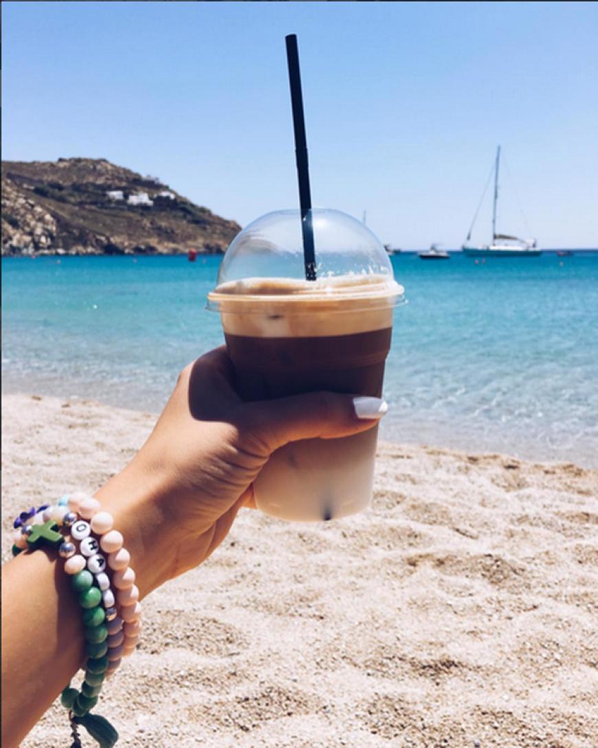 Perfekter Start in den Tag: Iced Cafe Latte, strahlender Sonnenschein und türkisblaues Meer
