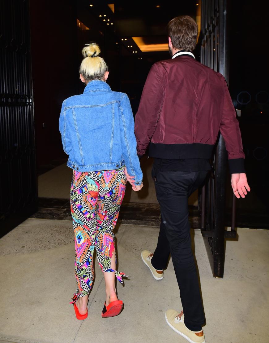 Miley Cyrus und Liam Hemsworth halten Händchen.