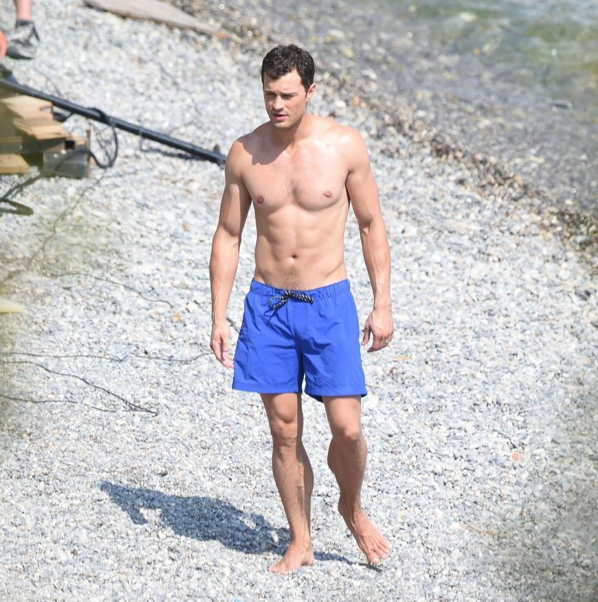 Jamie Dornan zeigt seinen trainierten Körper in einer blauen Badehose.