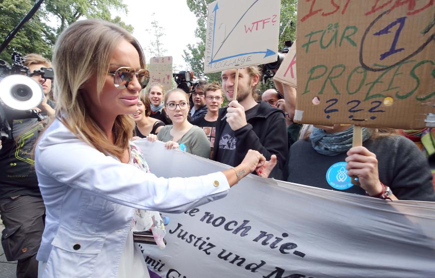 Welle der Unterstützung: Gina-Lisa Lohfink begrüßt die wartenden Demonstranten vor dem Berliner Gerichtsgebäude.