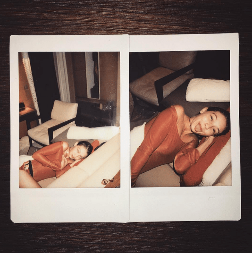Gigi Hadid rekelt sich im halbtransparenten Oberteil und lässt tief blicken.
