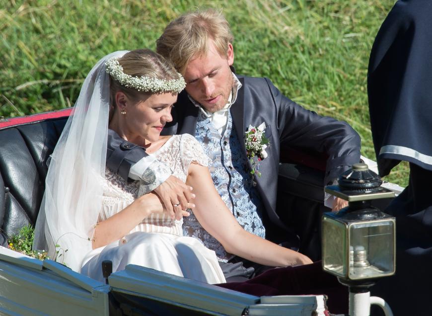 Während Samuel einen schicken Anzug trug, bezauberte Sarah in einem klassischen, weißen Brautkleid, das aus einem schlichten Rock und einem Oberteil mit Spitze bestand. Dazu trug sie einen süßen Blumenkranz mit Schleier auf dem Kopf. Einfach bezaubernd.