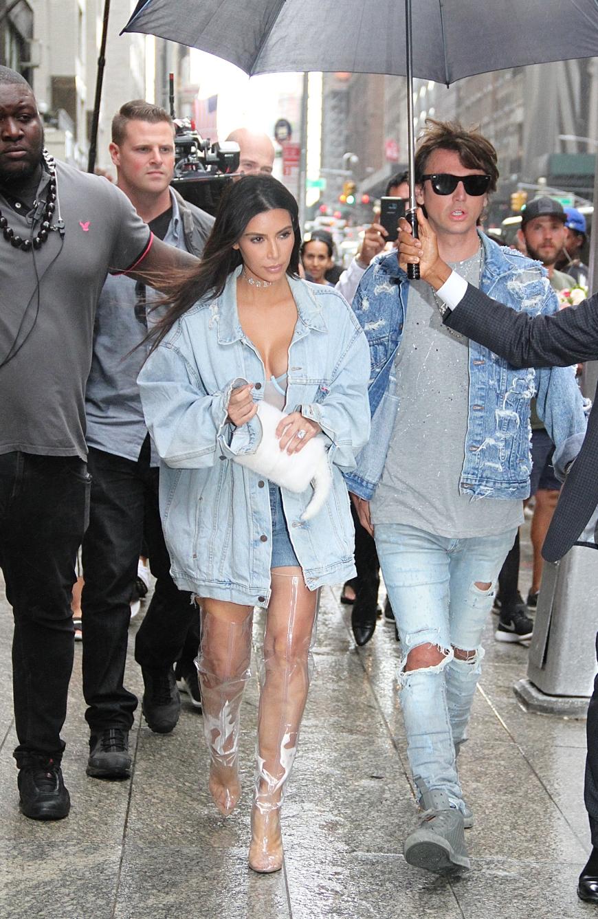 Kim Kardashian kombiniert dazu durchsichtige Overkneestiefel.