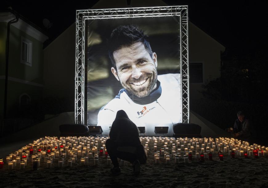 Auf dem Dorfplatz von Hannes' Heimatgemeinde wurde ein Foto des Verstorbenen aufgestellt, welches von einem Meer aus Lichtern beleuchtet wurde.