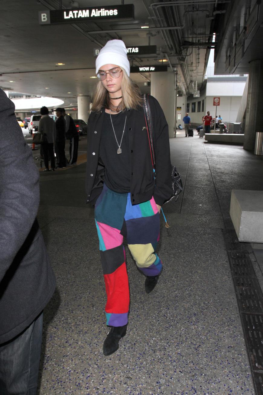 Cara Delevingne zeigt sich mit bunter Flickenhose und Nerd-Pilotenbrille bei ihrer Ankunft in Los Angeles.